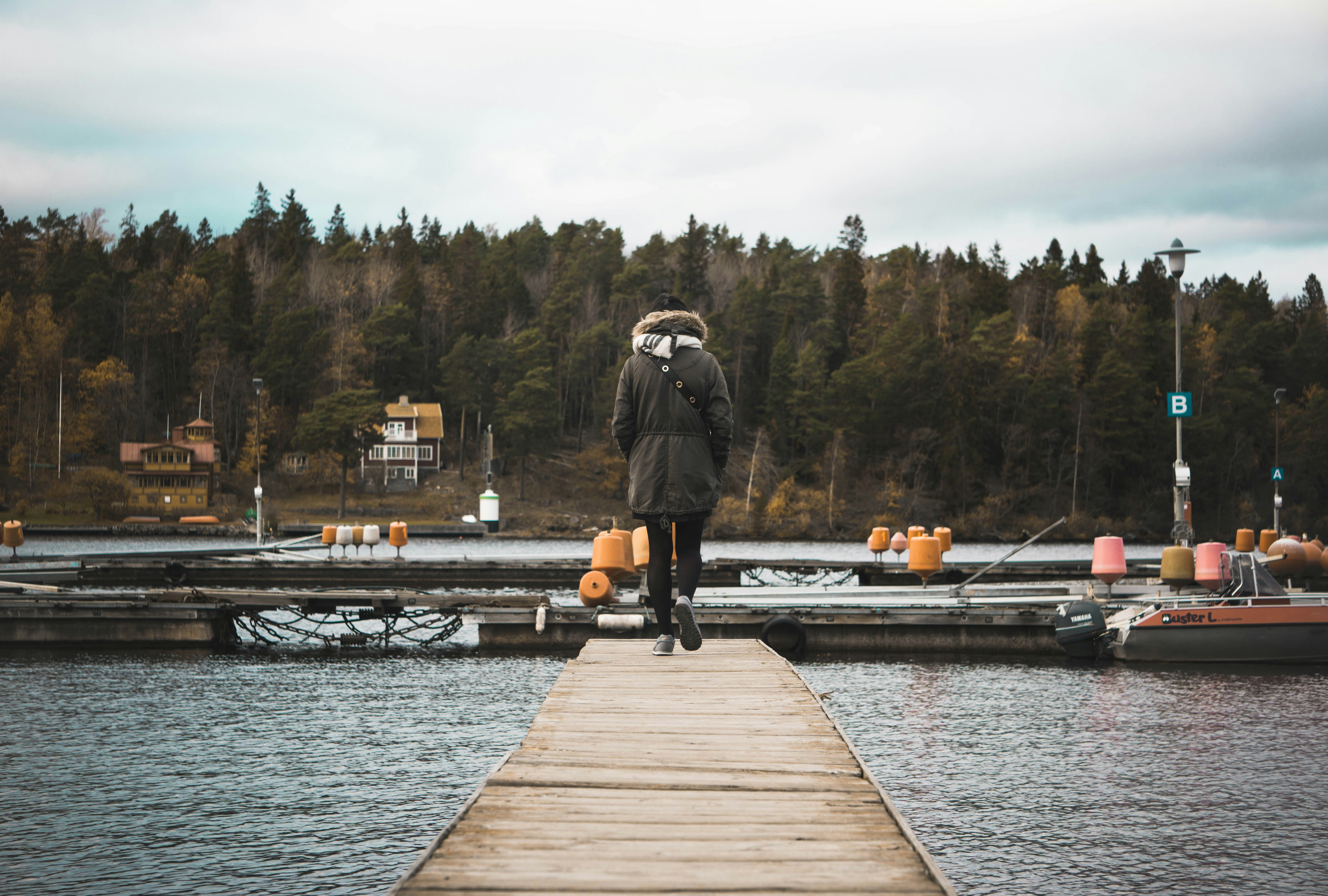 person walking on brown wooden boardwalk